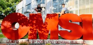 Two MESA students posing on top of the OMSI logo.