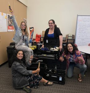 MESA staff members posing with tools in the MESA office